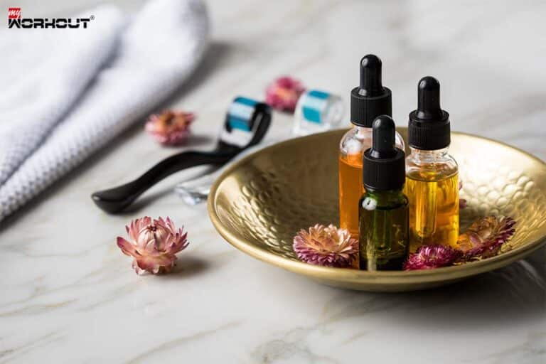 Entdecke die Kraft ätherischer Öle für Fitness und Wohlbefinden Schale mit ätherischen Ölen, Blumen und Gesichtsroller