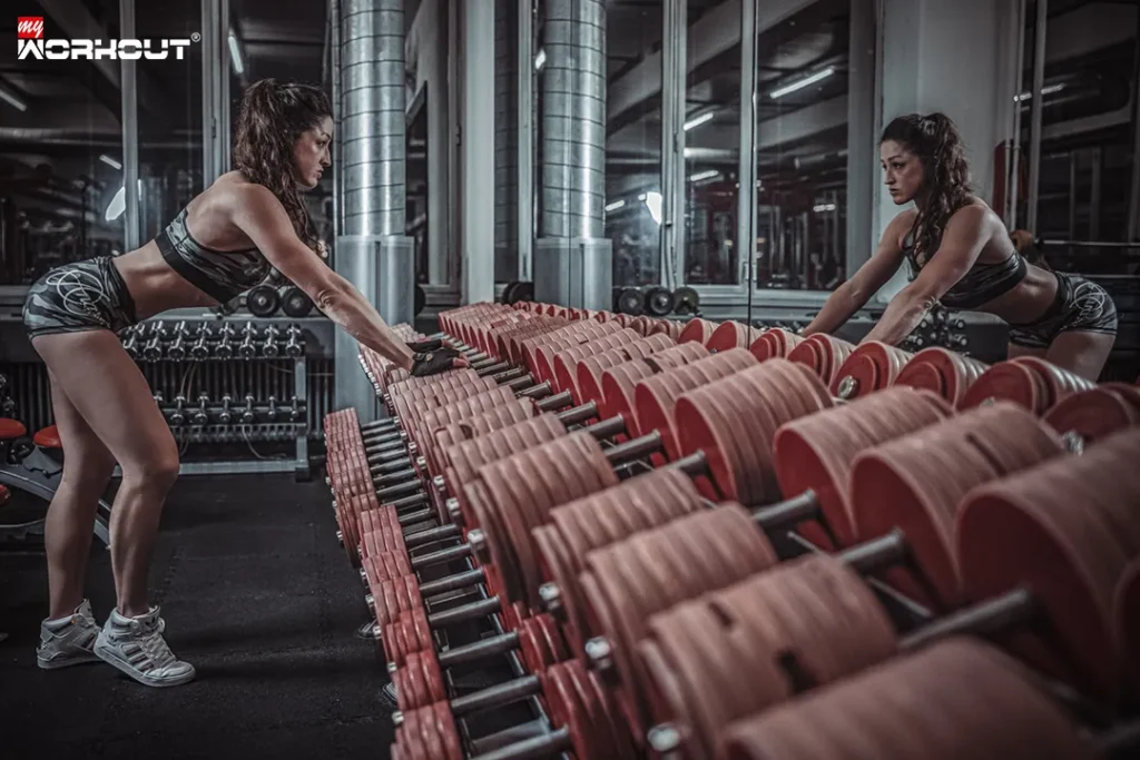 Frau im fitnessstudio schaut sich im spiegel an