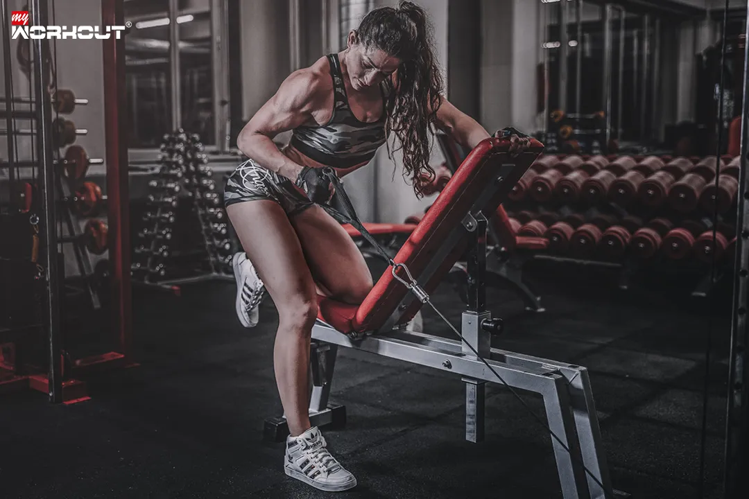 Frau im Fitnessstudio auf einer Hantelbank