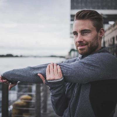 Dominic Zimmermann am Ufer eines Flusses in Sportkleidung