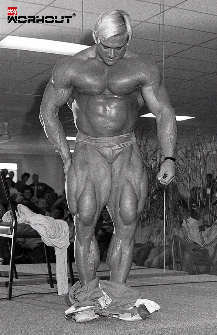 Tom Platz nur mit Slip bekleidet, zeigt seine massiven Beine an einem Seminar