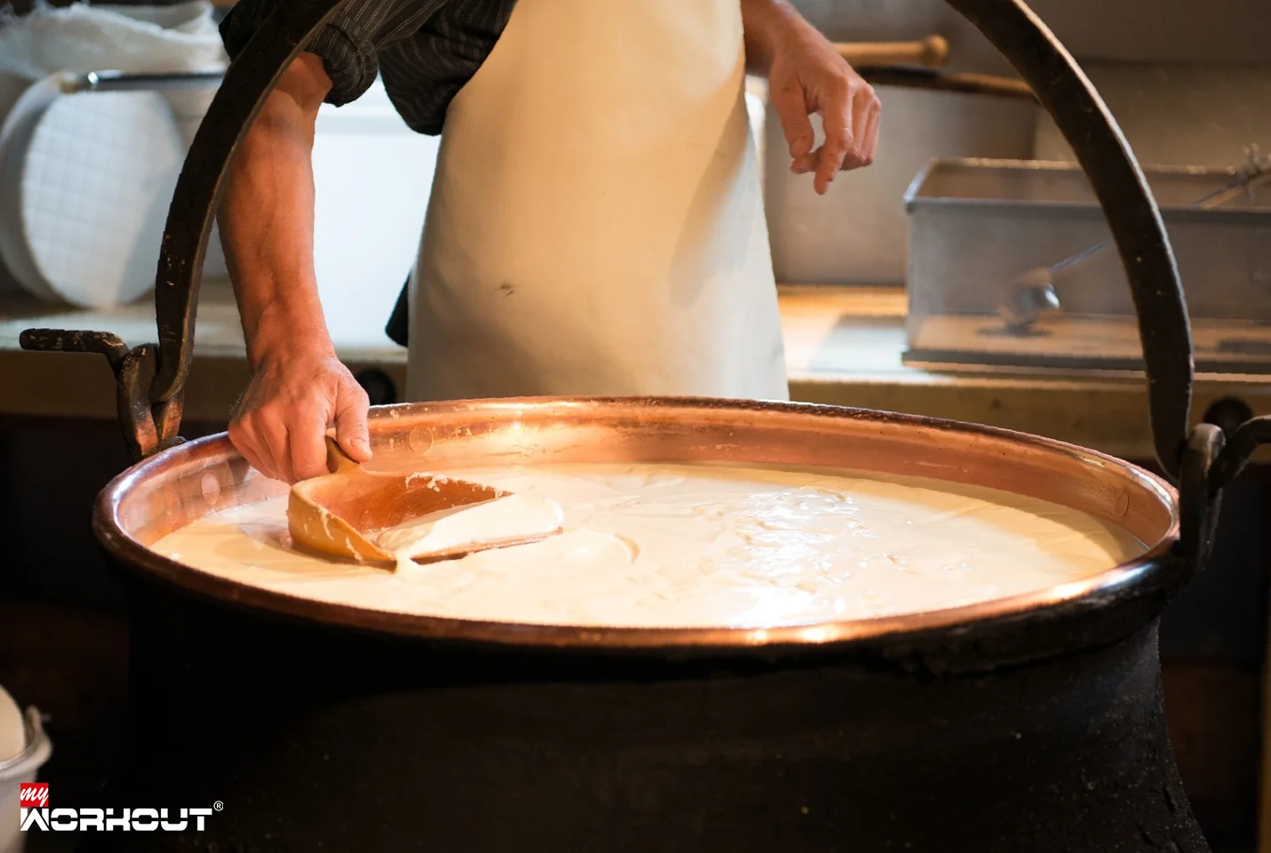 Ein Mann macht Käse in der Käserei